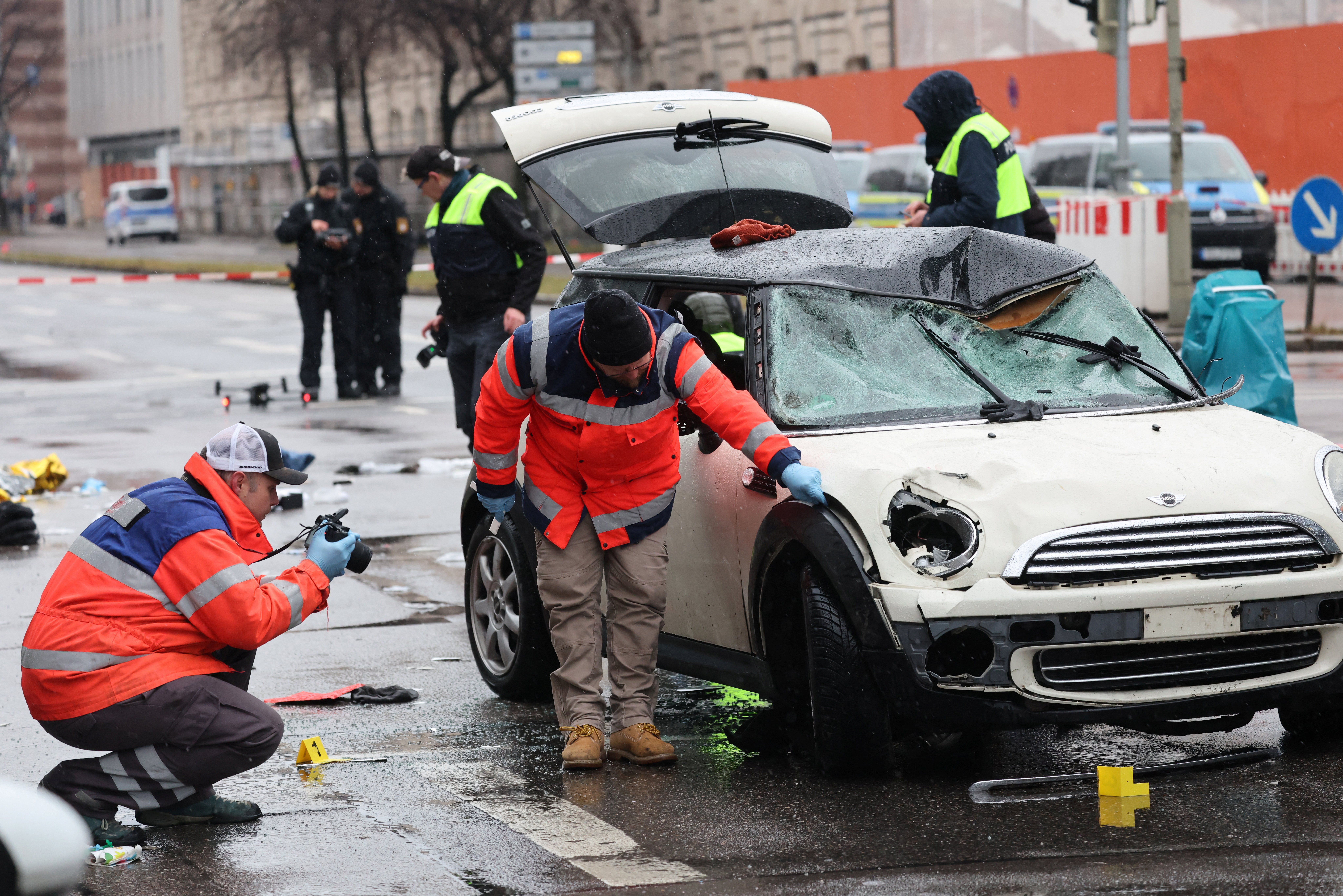 ​Police takes pictures of a car after some 28 people were hurt when a car driven by an Afghan asylum seeker plowed into a crowd in Munich, Germany, February 13, 2025. 