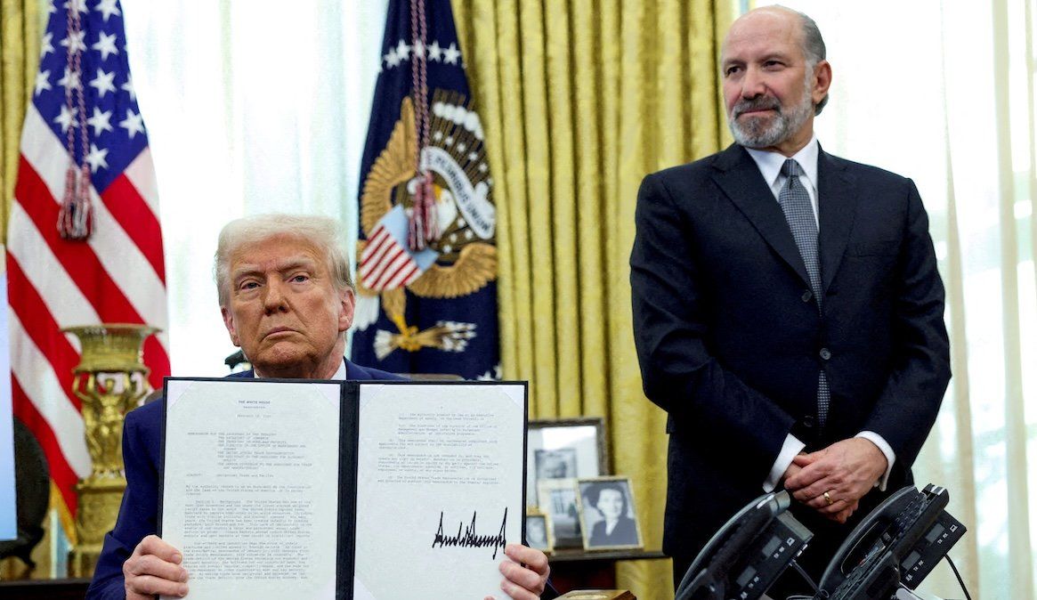 President Donald Trump holds an executive order about tariffs increase, flanked by Commerce Secretary Howard Lutnick.