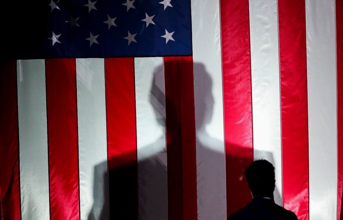 President-elect Donald Trump’s silhouette is seen against a United States flag at a campaign rally in October 2024. 