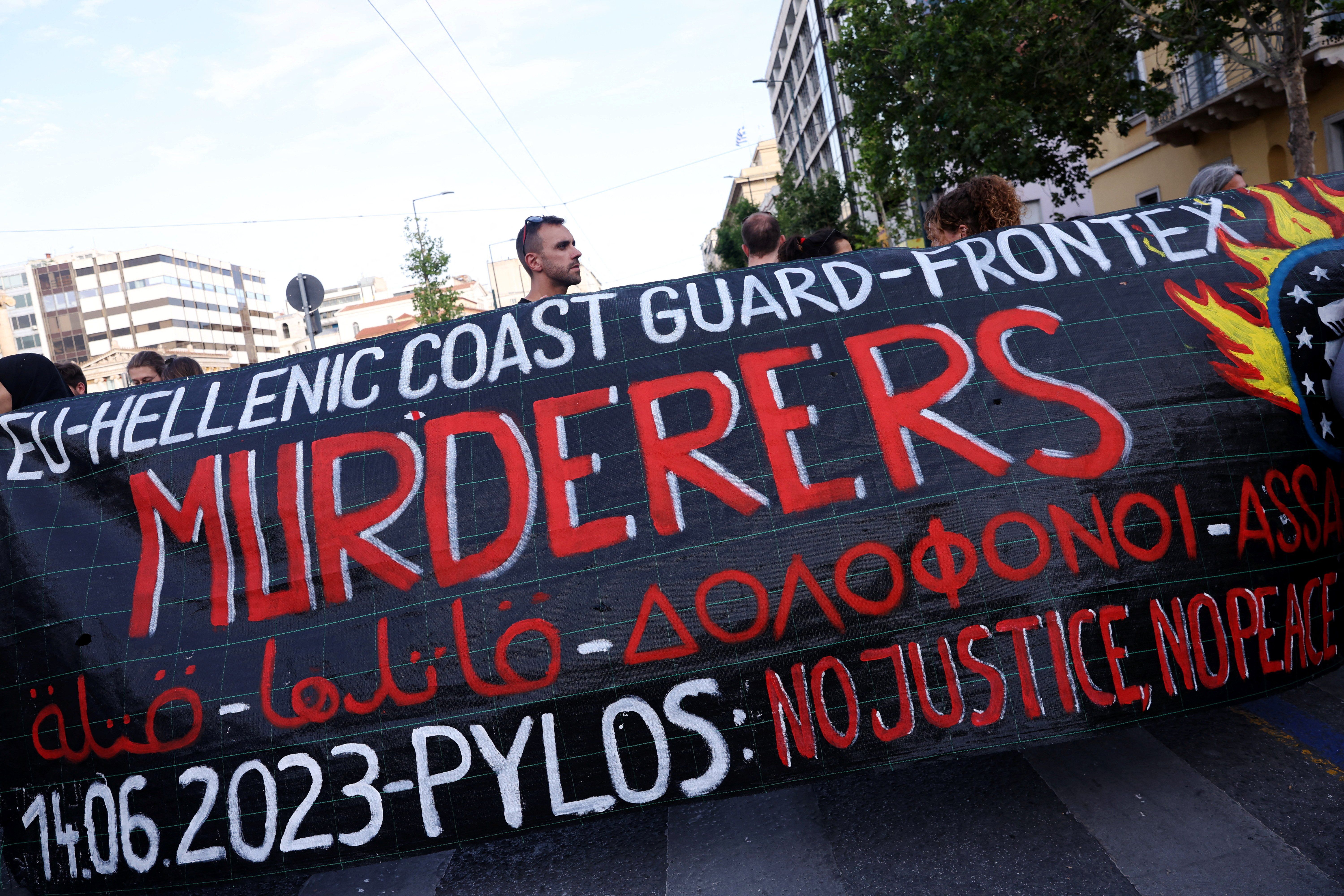 Protesters hold a banner during a demonstration in Athens following a deadly migrant shipwreck off Greece.