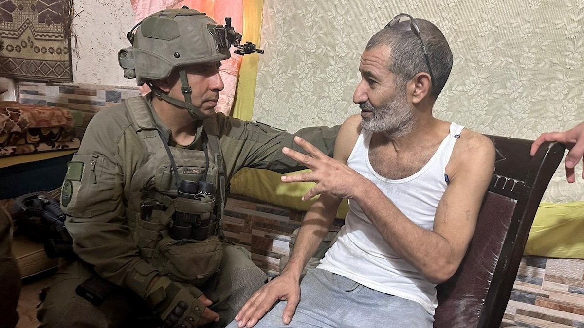 Qaid Farhan Alkadi, a Bedouin Israeli hostage who was kidnapped during the deadly October 7 attack, speaks with an Israeli soldier as he is rescued by Israeli forces, at unknown location, in this handout image obtained by Reuters on August 27, 2024.