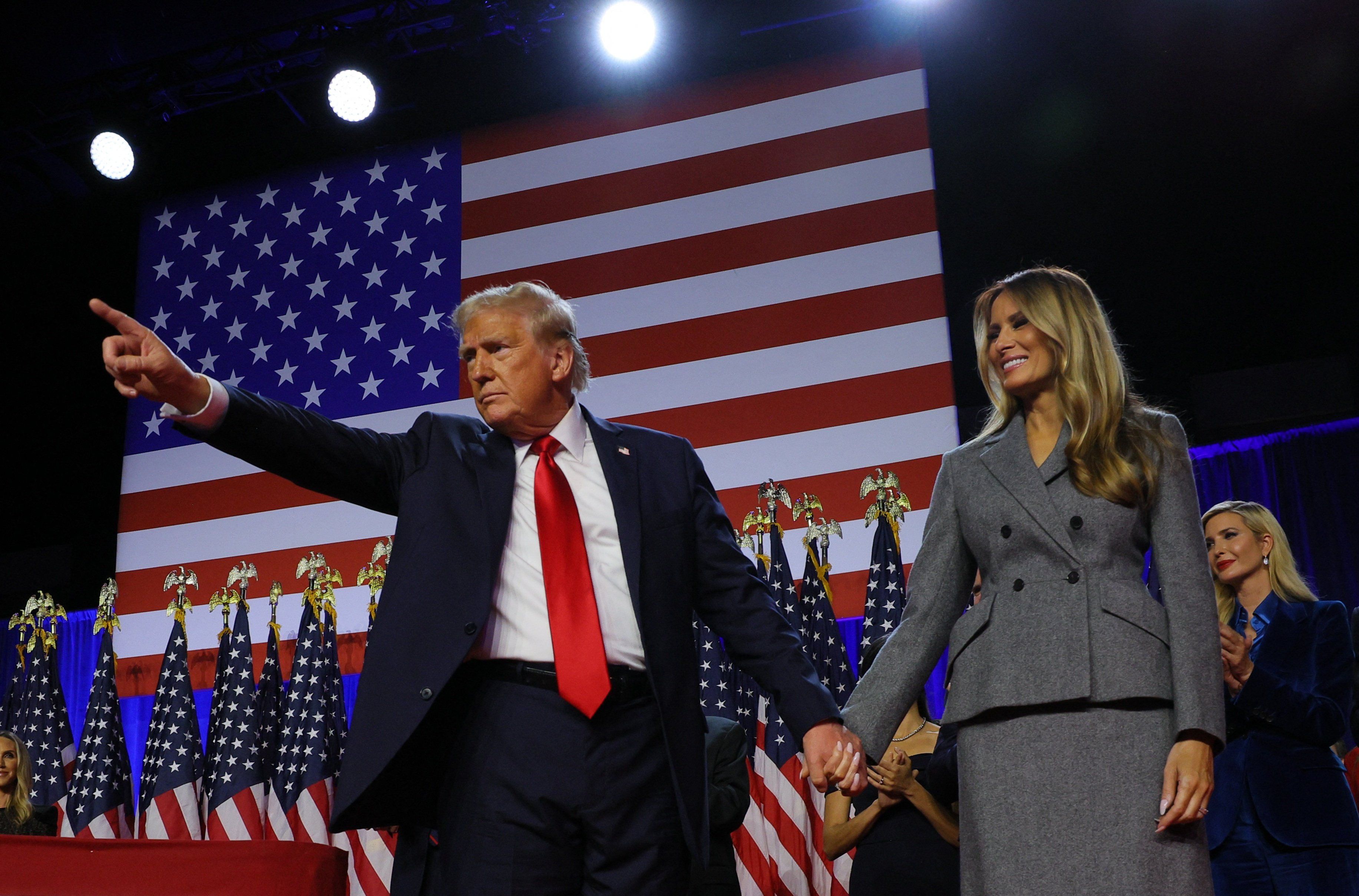 ​Republican presidential nominee and former U.S. President Donald Trump gestures as he holds hands with his wife Melania during his rally, at the Palm Beach County Convention Center in West Palm Beach, Florida, U.S., November 6, 2024. 