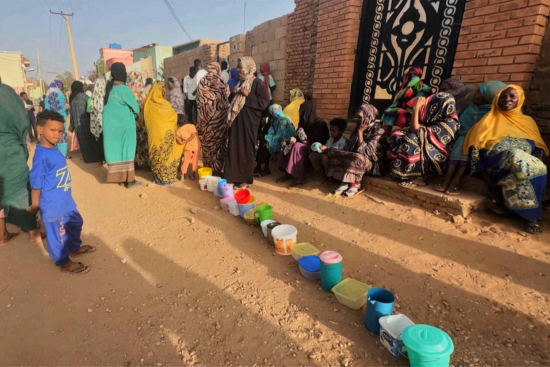 Residents wait to collect food in containers from a soup kitchen in Omdurman, Sudan March 11, 2024. Nearly five million people in the country are close to famine as Sudan's civil war passes the one-year mark. 