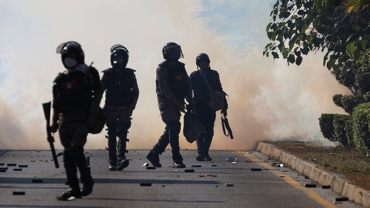 ​Security force personnel walk as smoke billows from tear gas shells fired to prevent an anti-government protest by supporters of the former Pakistani Prime Minister Imran Khan's party Pakistan Tehreek-e-Insaf (PTI) demanding the release of Khan, in Islamabad, Pakistan, November 26, 2024 