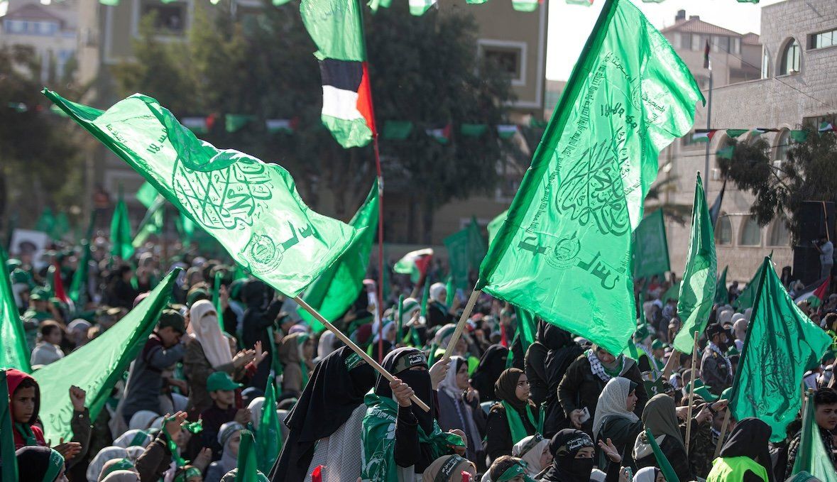 ​Supporters of Hamas wave their green flags during a celebration marking the 35th anniversary of the founding of Hamas in Gaza City in December 2022.