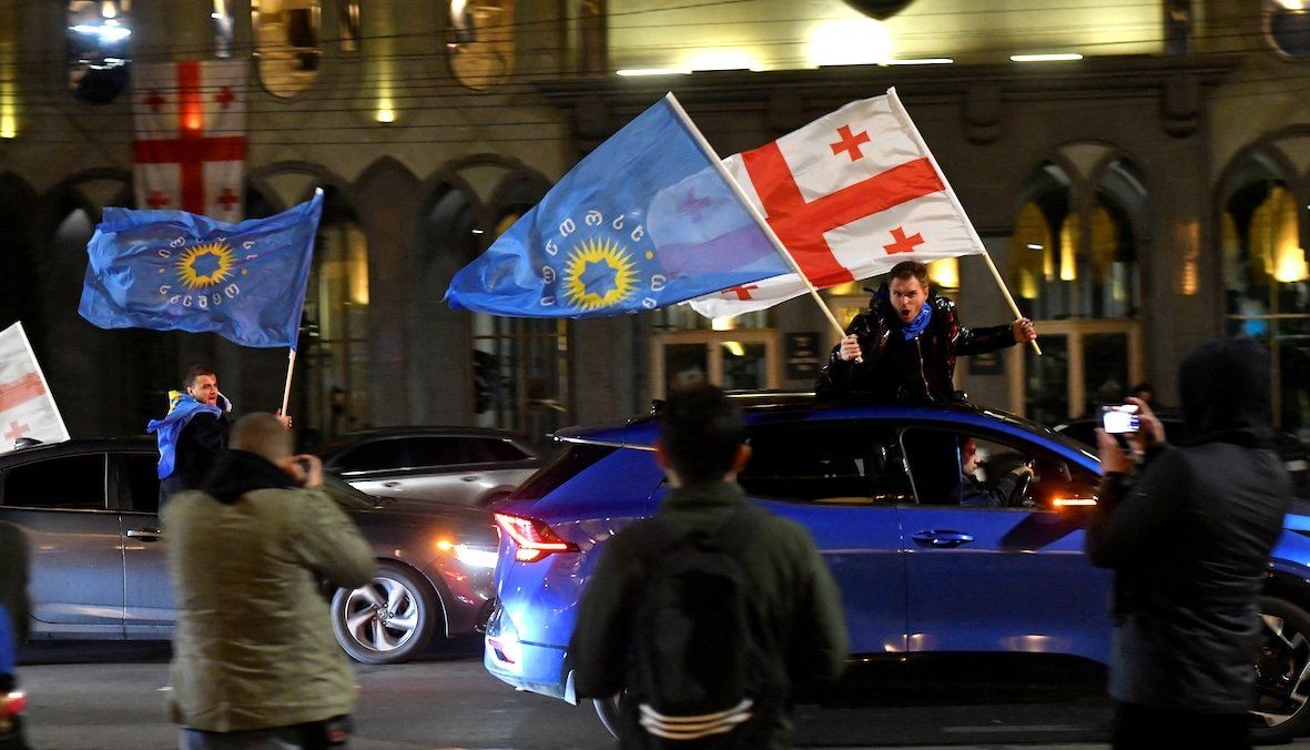 Supporters of the Georgian Dream party wave Georgian and party flags from cars after the announcement of poll results in parliamentary elections, in Tbilisi, Georgia, on Oct. 26, 2024. 