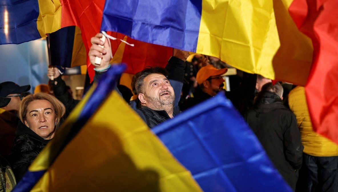 Supporters of the radical right Alliance for Uniting Romanians wave Romanian flags following the first exit polls, at the party’s campaign headquarters, on the day of the parliamentary election, in Bucharest, Romania, on Dec. 1, 2024. 