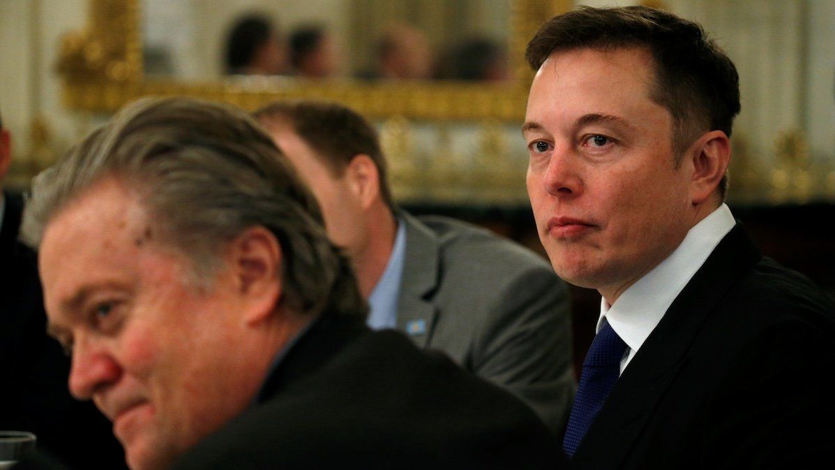 Tesla CEO Elon Musk, right, sits beside then-Senior Counselor to the President Steve Bannon, left