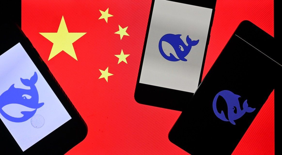 The DeepSeek logo is displayed on three cell phones in front of a computer screen showing the Chinese national flag. 