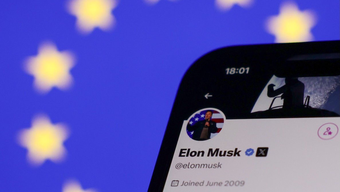 ​The European Union flag is displayed on a laptop screen and Elon Musk's account on X is displayed on a phone screen.