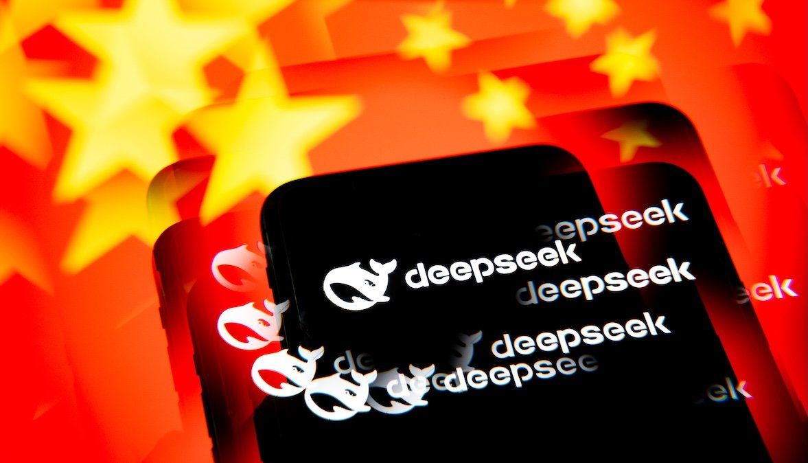 ​This illustration photo shows the DeepSeek AI application logo on a black background displayed on a cell phone with a kaleidoscope-effect China flag in the background. 