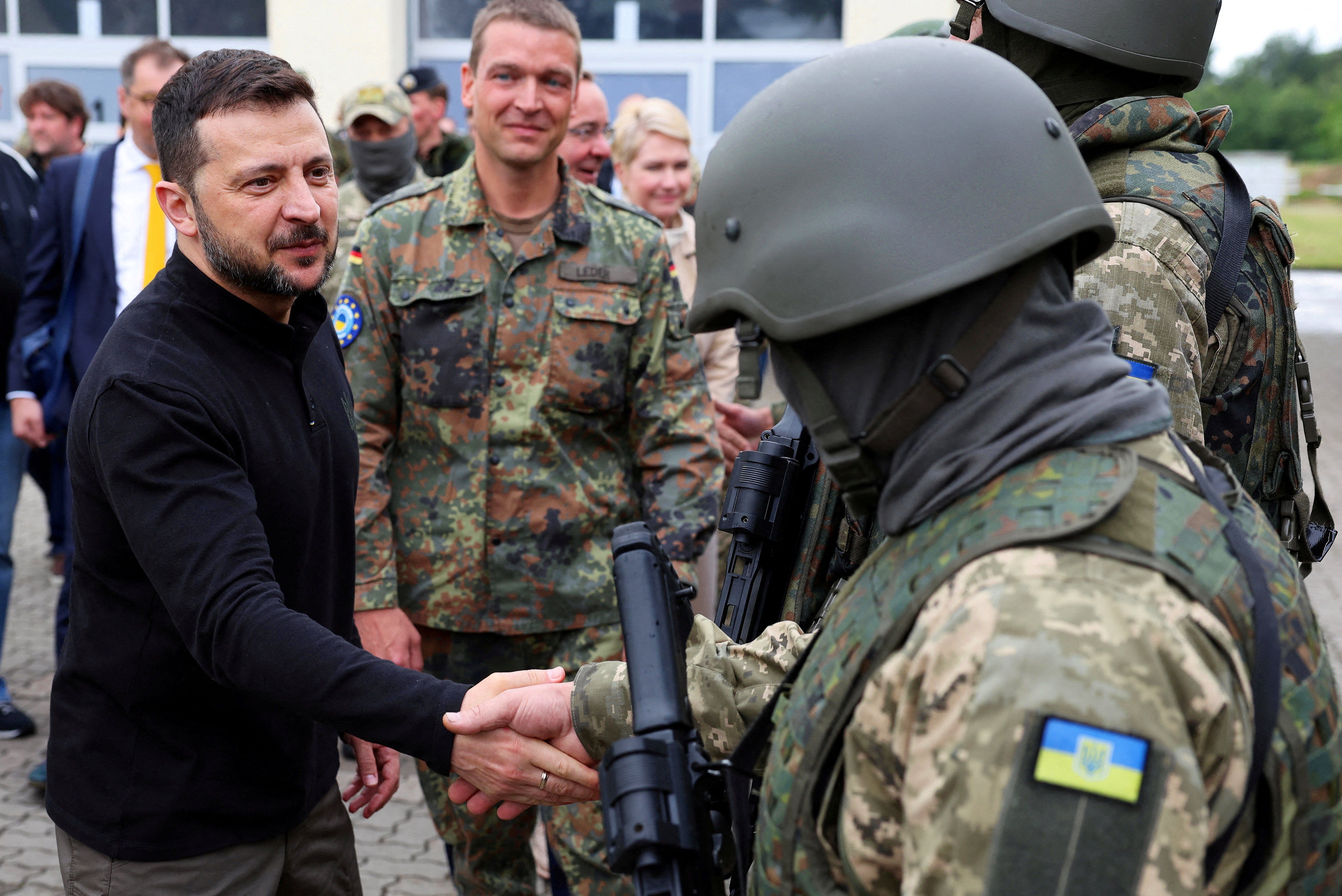 Ukrainian President Volodymyr Zelenskiy interacts with soldiers during his visit to a military training area to find out about the training of Ukrainian soldiers on the ?Patriot? anti-aircraft missile system, at an undisclosed location, in Germany, June 11, 2024. 