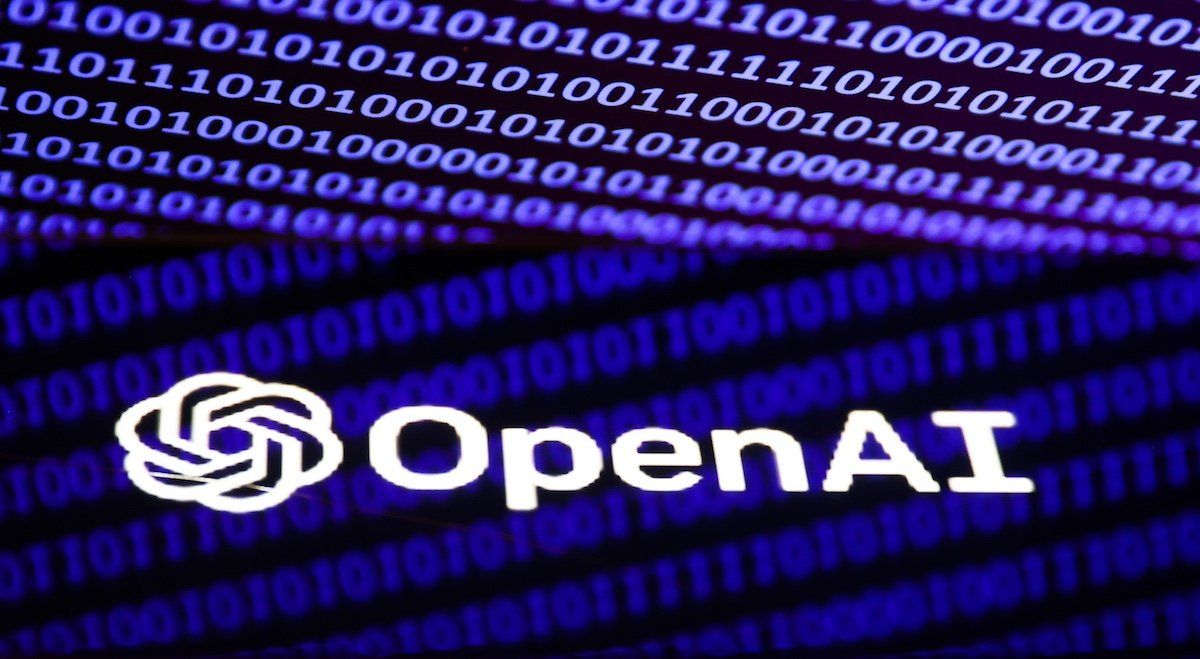 OpenAI logo displayed on a phone screen and binary code displayed on a laptop screen are seen in this illustration photo taken in Krakow, Poland on December 5, 2022.