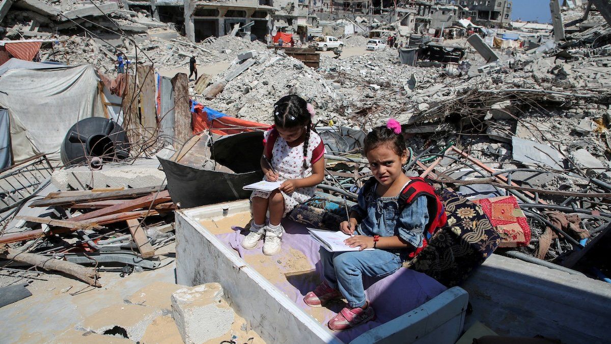 Palestinian students sit on the rubble after attending a class in a tent set up on the ruins of the house of teacher Israa Abu Mustafa, as war disrupts a new school year, amid the Israel-Hamas conflict, in Khan Younis, in the southern Gaza Strip, September 4, 2024. 