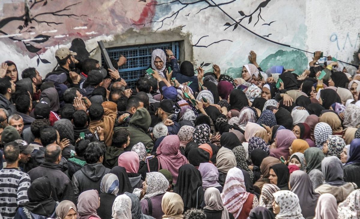 Palestinians gather to receive aid outside an UNRWA warehouse earlier this month in Gaza.