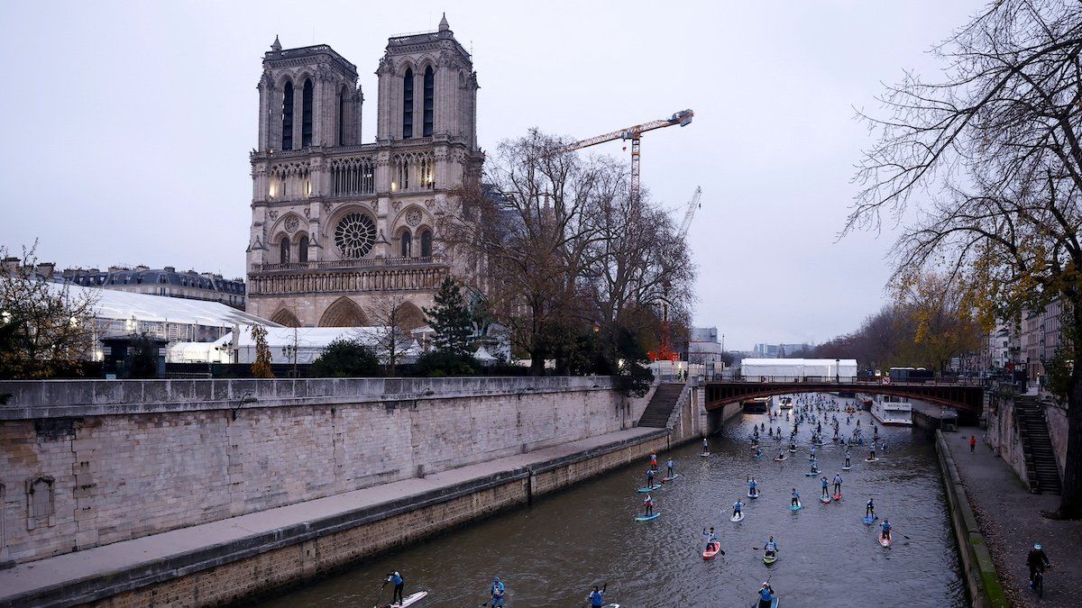 ​Participants make their way past the Notre-Dame Cathedral as they attend the 13th edition of the stand up Nautic Paddle race on the river Seine in Paris, France, December 1, 2024. 