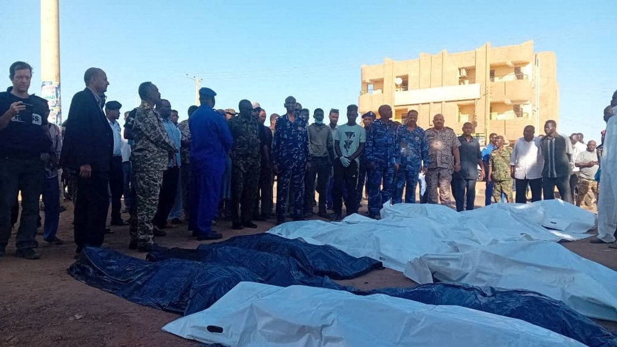 ​People gather next to covered bodies, following shelling by the Rapid Support Forces, in Omdurman, Sudan, December 10, 2024. 