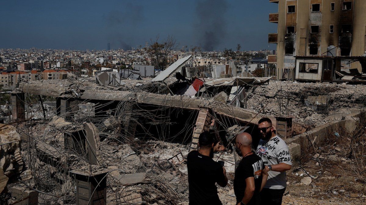 ​People stand amid damage caused by Israeli airstrikes, as smoke rises over Beirut southern suburbs, amid ongoing hostilities between Hezbollah and Israeli forces, at Choueifat district, in Beirut, Lebanon, October 3, 2024. 