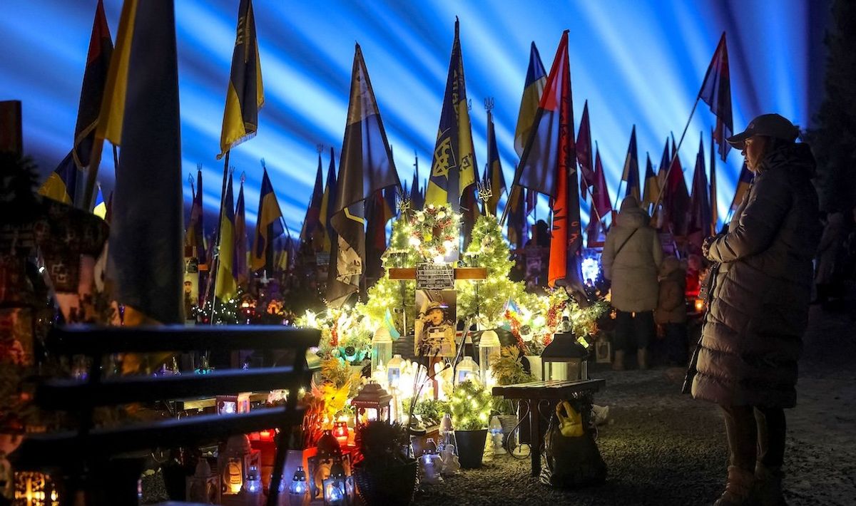 ​People visit the graves of their relatives killed during Russia's invasion of Ukraine. A large-scale light installation "Lights of Memory" was held to mark the third anniversary of the full-scale Russian invasion at the Lychakiv cemetery in Lviv, Ukraine, on Feb. 23, 2025. 