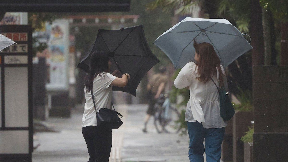 People walk against strong wind in Kagoshima on Aug. 29, 2024, as Typhoon Shanshan made landfall on Japan's southwestern main island of Kyushu.