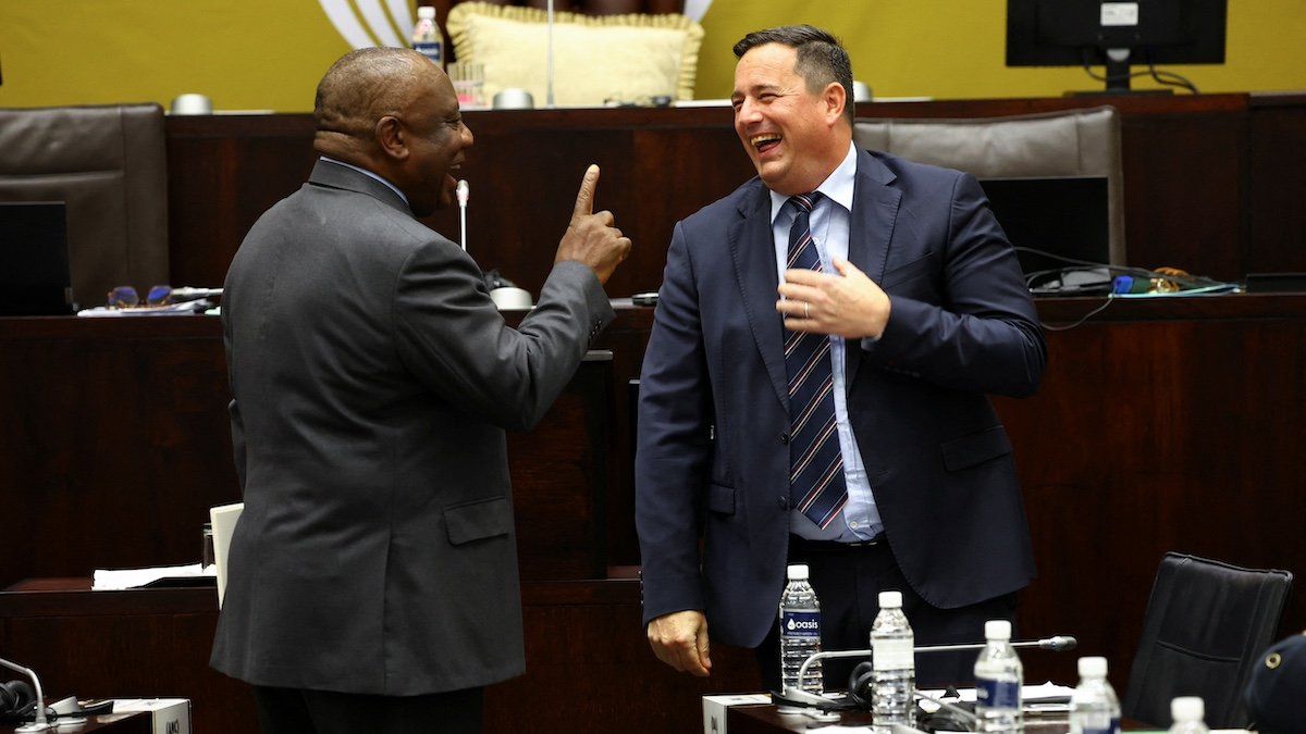 ​South African President Cyril Ramaphosa interacts with the leader of the opposition party, John Steenhuisen ahead of National Assembly members' questions in parliament in Cape Town, South Africa, November 3, 2022. 