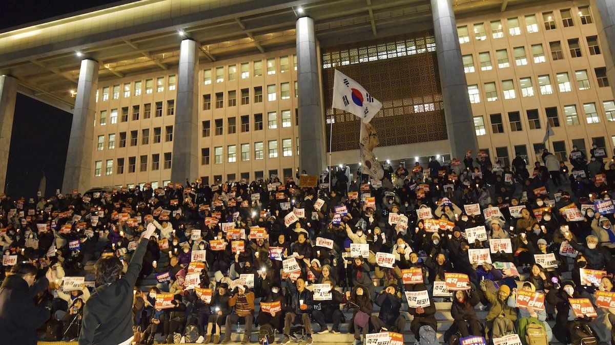 South Korean protestors calling for the dismissal and impeachment of South Korean President Yoon Suk Yeol outside the National Assembly in Seoul, South Korea, on December 4, 2024. South Korean President Yoon Suk Yeol briefly declared martial law on December 3, 2024, citing threats to democracy from opposition lawmakers he labeled as pro-North Korea. The decree, which restricted political activities, media, and strikes, was quickly overturned by the National Assembly. The event highlights rising tensions and Yoon’s declining authority following significant opposition victories in recent elections. 