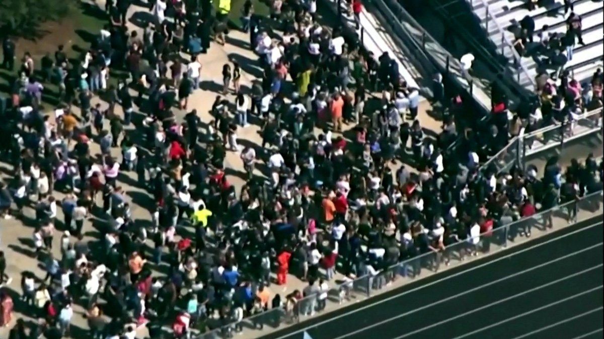 ​Students and staff gather next to the football field after law enforcement officers responded to a fatal shooting at Apalachee High School in a still image from aerial video in Winder, Georgia, U.S. September 4, 2024. 