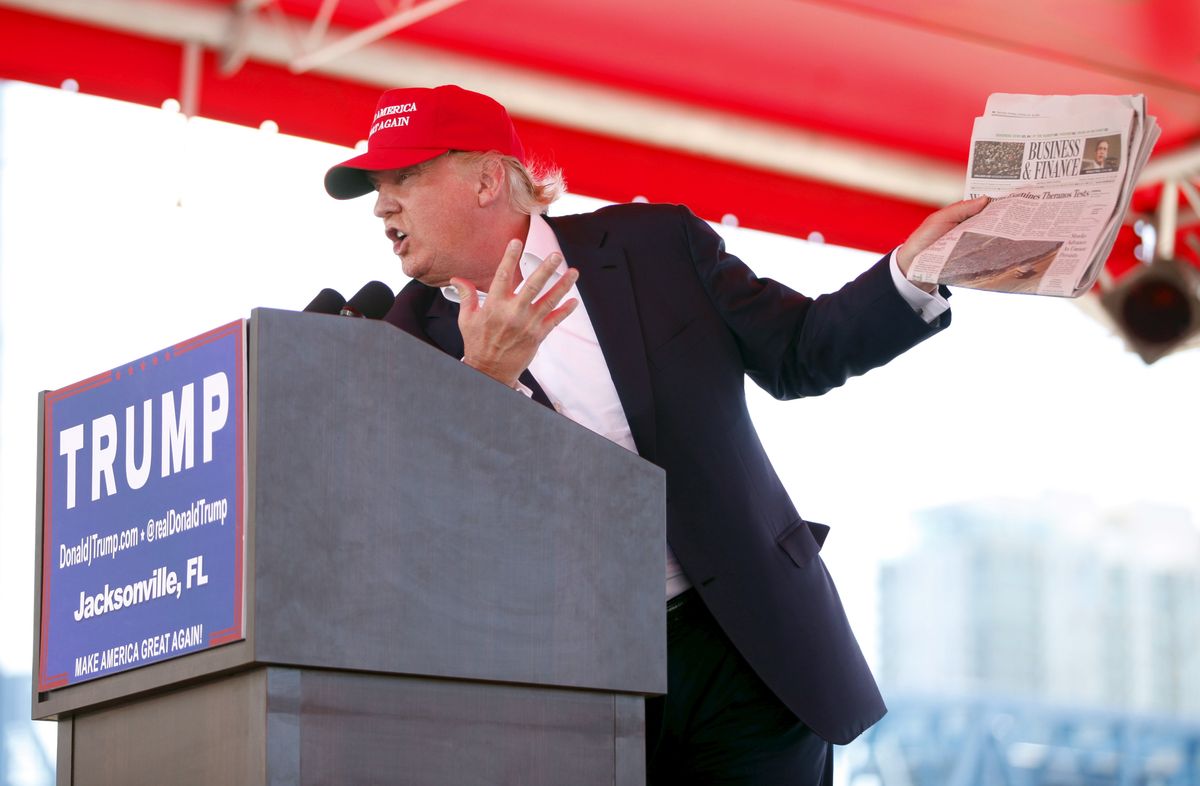 ​U.S. Republican presidential candidate Donald Trump holds a copy of the Wall Street Journal while speaking at a Trump for President campaign rally at the Jacksonsville Landing in Jacksonville, Florida.