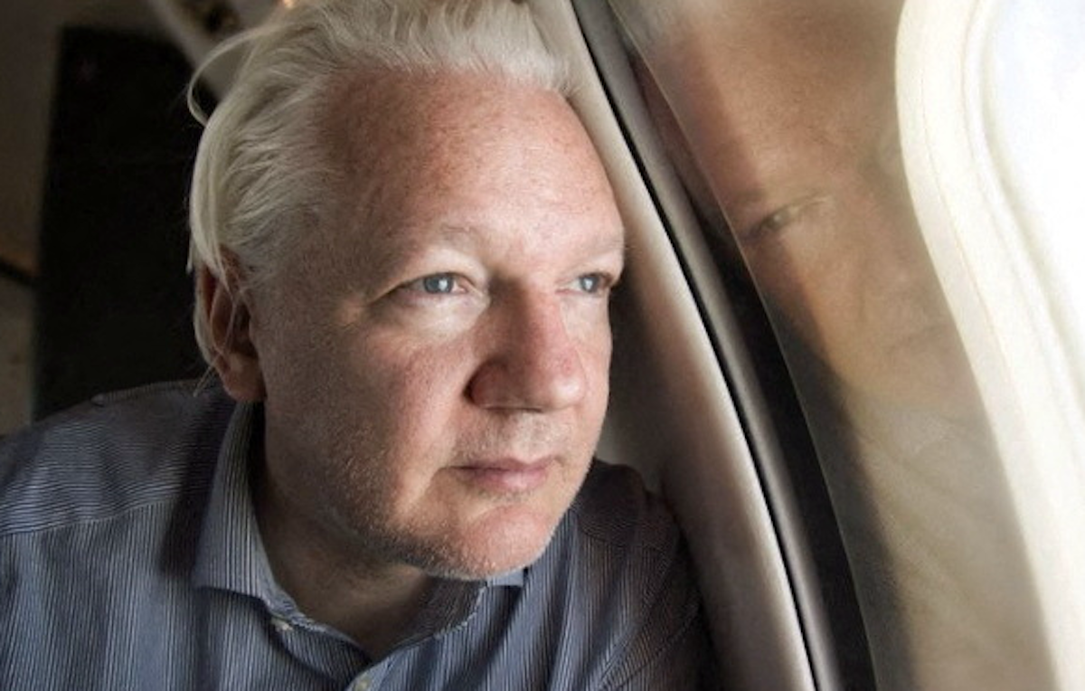​Wikileaks founder Julian Assange looks out a plane window as he reportedly approaches Bangkok airport for a layover. 